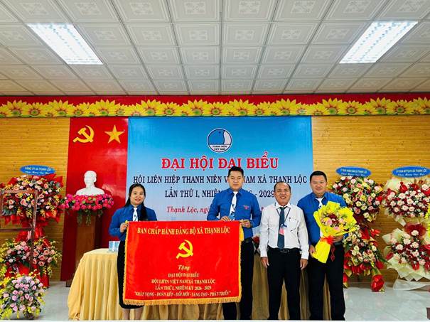A group of people standing in front of a bannerAI-generated content may be incorrect.